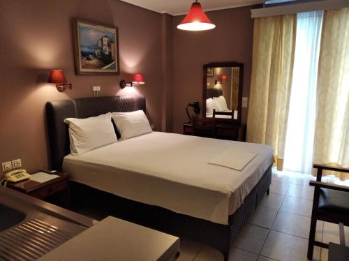 1 dormitorio con 1 cama grande en una habitación de hotel en Hotel Romantica, en Loutra Edipsou