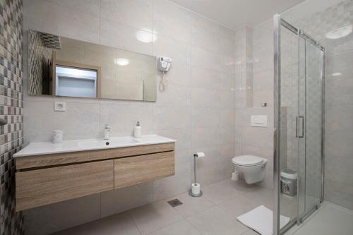 uma casa de banho com um WC, um lavatório e um chuveiro em Residence Panorama em Medulin