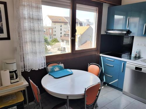 a small kitchen with a table and a window at SUNNY DAYS - App 60 m2 avec balcon, 4 pers, 3e étage, au calme et ensoleillé in Le Touquet-Paris-Plage