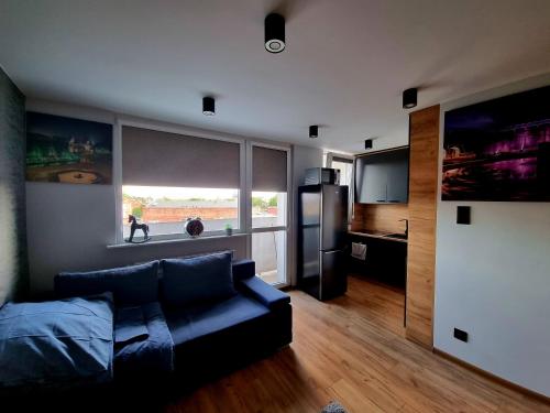 uma sala de estar com um sofá e um frigorífico em Apartament PJ Prestige em Inowrocław