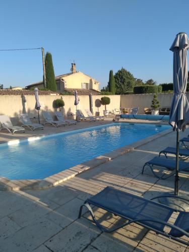 une piscine avec des chaises longues et un parasol dans l'établissement Mas Dansavan Chambres d'hôtes, à Oppède