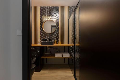 a bathroom with a mirror and a shelf with towels at Short Stay Apartments in Gdańsk