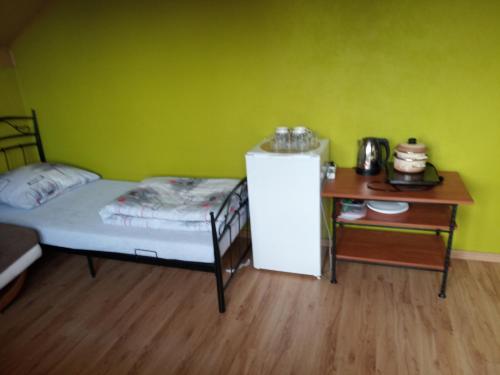 ein Schlafzimmer mit einem Bett und einem Schreibtisch mit einem kleinen Kühlschrank in der Unterkunft Noclegi Lawenda in Grodzisko