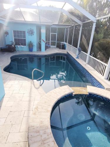 a swimming pool in a yard with a house at Cape Paradise B & B - Your Luxury Tropical Retreat in Cape Coral
