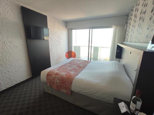 a hotel room with a bed and a window at Hôtel Le Nautic in Arcachon