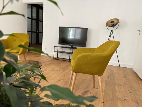 a living room with two chairs and a television at SCHLOSS & ALTSTADT - Modern & Stylish für 6 Küche in Dachau