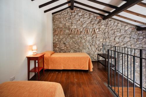 a room with two beds and a stone wall at Agriturismo Ristorante Monte Argentario in Monte Argentario