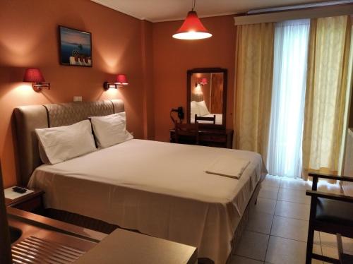 a hotel room with a large bed and a mirror at Hotel Romantica in Loutra Edipsou