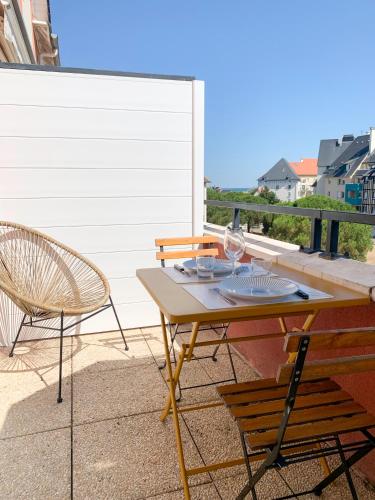 une table et des chaises sur un balcon avec vue sur l'océan dans l'établissement Duplex 2 pièces Port Cabourg - 2 à 4 personnes - Terrasse - Vue Port - Exclusif Book ing, à Dives-sur-Mer