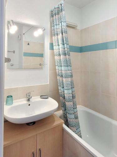 une salle de bain avec un lavabo et une baignoire dans l'établissement Duplex 2 pièces Port Cabourg - 2 à 4 personnes - Terrasse - Vue Port - Exclusif Book ing, à Dives-sur-Mer