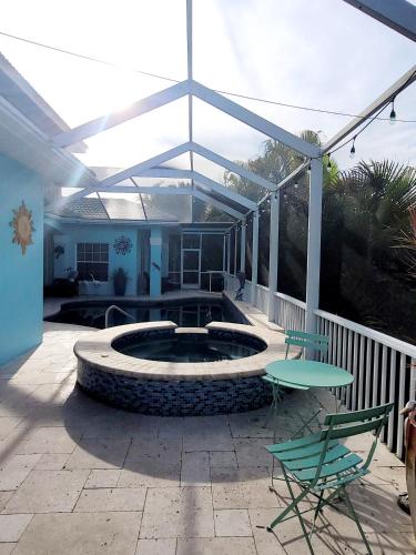 a patio with a pool and a table and chairs at Cape Paradise B & B - Your Luxury Tropical Retreat in Cape Coral