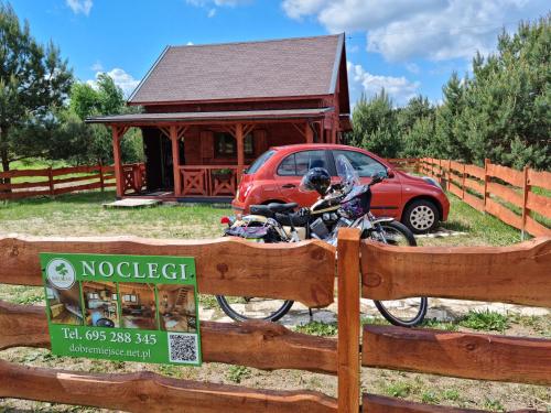 a motorcycle parked behind a fence in front of a house at Dobre Miejsce na Roztoczu in Huta Różaniecka
