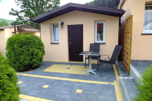 a patio with a table and chairs in front of a house at Ośrodek Wypoczynkowy Beskid in Międzybrodzie Bialskie