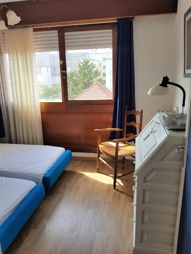 une chambre avec un lit, une fenêtre et une chaise dans l'établissement SUNNY DAYS - App 60 m2 avec balcon, 4 pers, 3e étage, au calme et ensoleillé, à Le Touquet-Paris-Plage