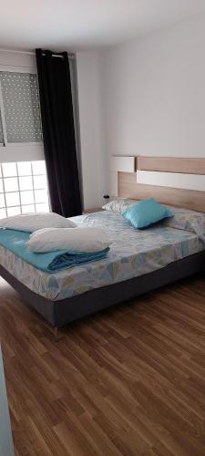 Bett in einem Schlafzimmer mit Holzboden in der Unterkunft Lyesblb in Valencia