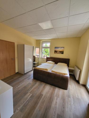 a large bedroom with a bed and a refrigerator at Haus Kim - Apartments in Waren