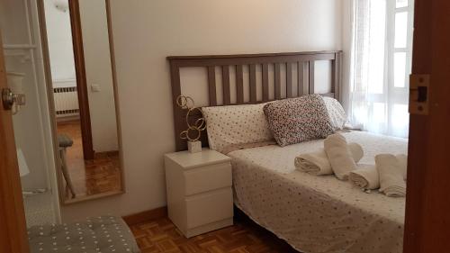 a bedroom with a bed with two pillows and a mirror at Apartamento BCN con balcón in Barcelona