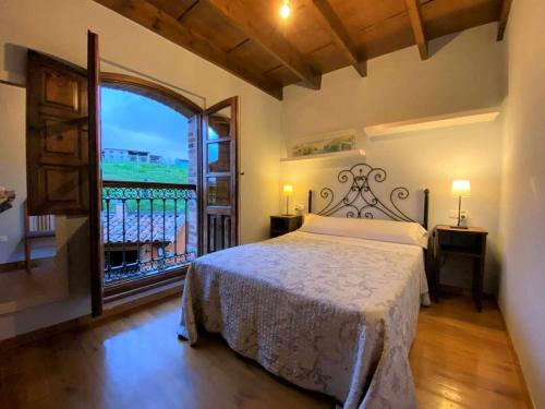 a bedroom with a bed and a large window at Vivienda Vacacional La Vara VV-1433-AS in Arriondas