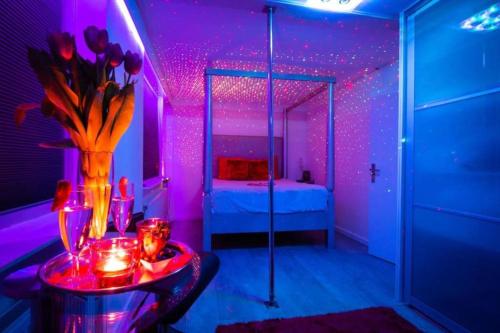 a purple room with a bed and a vase of flowers at The Waterside Designer Waterfront Oasis Spa & Sauna Terrace in Zwanenburg