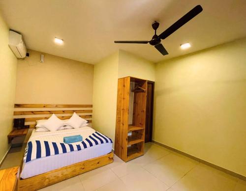 a bedroom with a bed and a ceiling fan at Endheri Sunset Dhangethi in Dhangethi