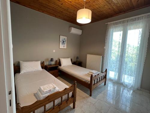 a bedroom with two beds and a window at Gazena House in Sívros