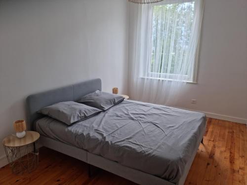 Ce lit se trouve dans un dortoir blanc doté d'une fenêtre. dans l'établissement Gite de cuminaille, à Chavanay