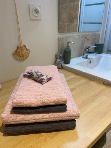 un mucchio di asciugamani seduti su un bancone in bagno di Le Gîte de La Source a Saint-Guilhem-le-Désert