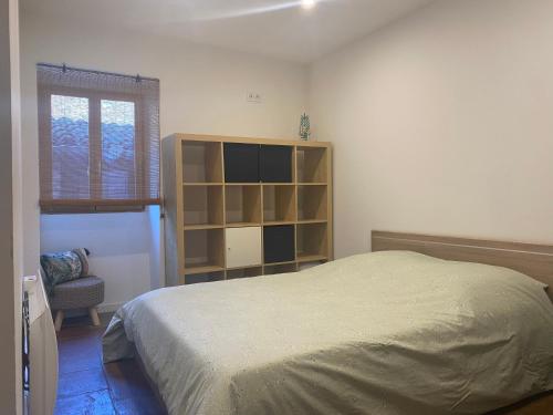 um quarto com uma cama e uma estante de livros em Le Gîte de La Source em Saint-Guilhem-le-Désert