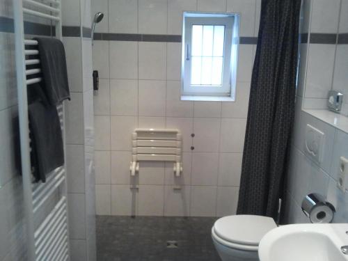 a bathroom with a toilet and a window at Mary´s Ferienwohnung in Kevelaer