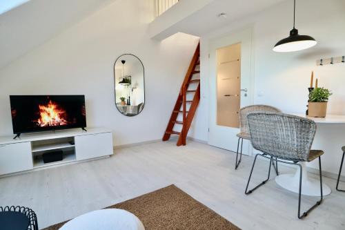 a living room with a tv and a staircase at GALLERY APARTMENT: MAISONETTE + FREE PARKING + NETFLIX in Essen