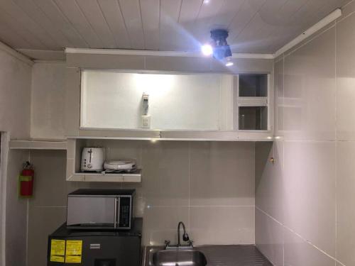 a kitchen with a sink and a microwave at Pinky’s Place Airport, Full Equipment. in Alajuela City