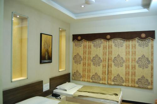a room with two beds and a mirror at Hotel Purva in Indore