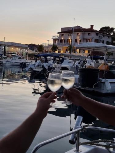 two people are holding wine glasses in a marina at Villa Riva in Omišalj