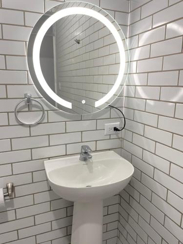 a white bathroom with a sink and a mirror at Hotel Hasta La Vista in Antigua Guatemala