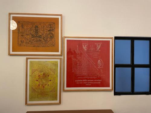 four framed pictures on a wall next to a window at Hotel Hasta La Vista in Antigua Guatemala