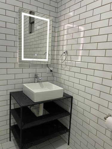 ein weißes Badezimmer mit einem Waschbecken und einem Spiegel in der Unterkunft Hotel Hasta La Vista in Antigua Guatemala