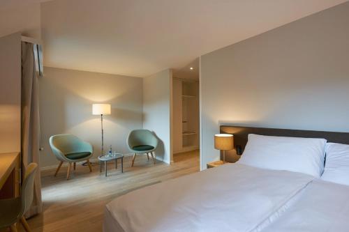 Volketswil的住宿－瓦爾貝格公園酒店，一间卧室配有一张床、两把椅子和一张桌子