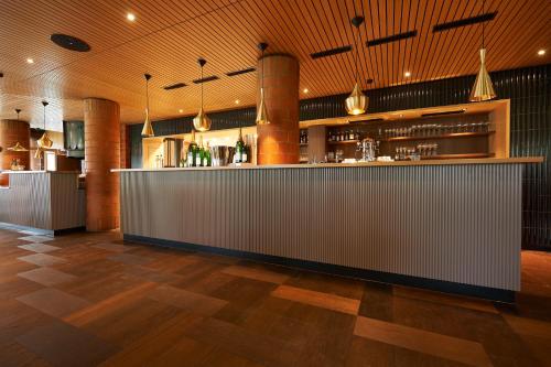a bar in a restaurant with a counter at Parkhotel Wallberg in Volketswil