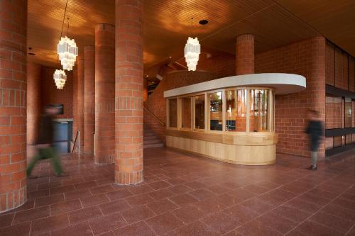 a building with brick columns and people walking in it at Parkhotel Wallberg in Volketswil