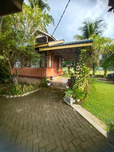a house with a brick driveway in front of it at AMBOW Homestay Jungle Trekking & Village Tour in Bukit Lawang