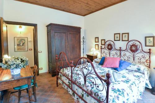a bedroom with a large bed and a wooden table at Appartamento Le Macine in Isola d'Arbia