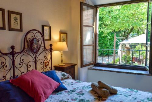 a bedroom with a bed and a large window at Appartamento Le Macine in Isola d'Arbia