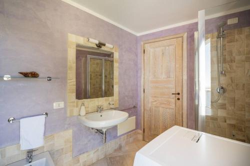 a bathroom with a sink and a toilet and a tub at Seafront Villa - 5min to BRANDINCHI I Exclusive Garden I Private Beach I BBQ I Wi-Fi in San Teodoro