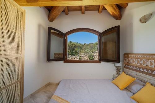 a bedroom with a bed and a window in a room at Seafront Villa - 5min to BRANDINCHI I Exclusive Garden I Private Beach I BBQ I Wi-Fi in San Teodoro