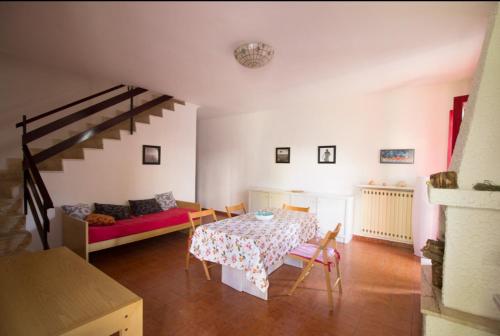 een woonkamer met een tafel en een bed bij Villa Casaluce con giardino a 5 minuti dalle spiagge in Porto Cesareo