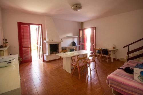 een keuken en een woonkamer met een tafel en een open haard bij Villa Casaluce con giardino a 5 minuti dalle spiagge in Porto Cesareo