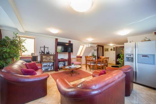 a living room with leather furniture and a refrigerator at Tamás Apartman Balatonföldvár szívében- egész évben nyitva! in Balatonföldvár
