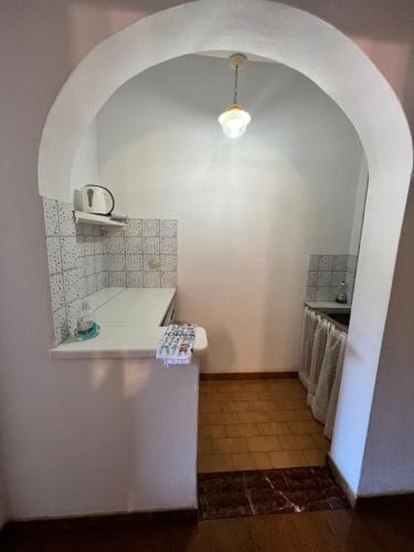 a bathroom with a white counter and an archway at ERIDA Accommodation in Lákka