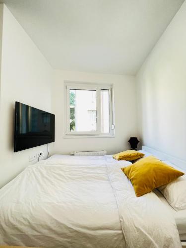 - une chambre blanche avec 2 lits et une télévision à écran plat dans l'établissement A 102, apartments in the heart of the jewish quarter, à Budapest