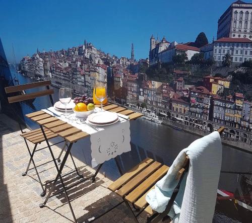 a table on a balcony with a view of a city at CELLARS CENTER HOUSE in Vila Nova de Gaia